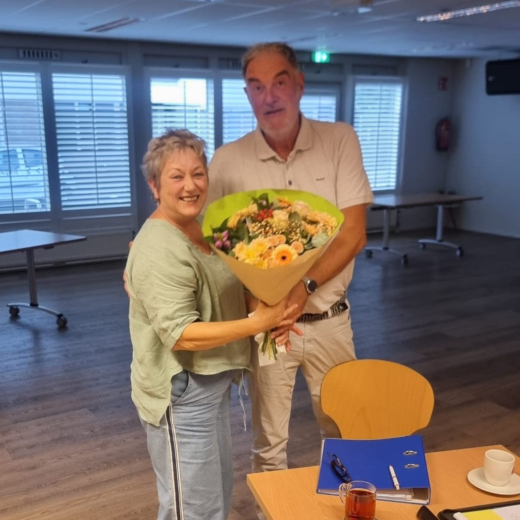 Berna krijgt bloemen voor haar rol in het bestuur. 